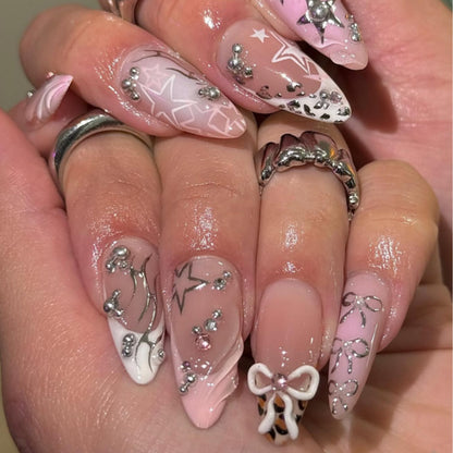 Kunstvolle Stiletto-Nägel mit Glitzer- und Schleifenverzierungen Brehn