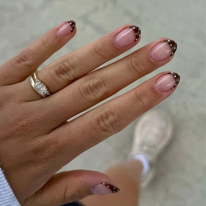 Kunstvolle Nagelkunst mit eleganten French-Spitzen und Glitzerakzenten Brehn