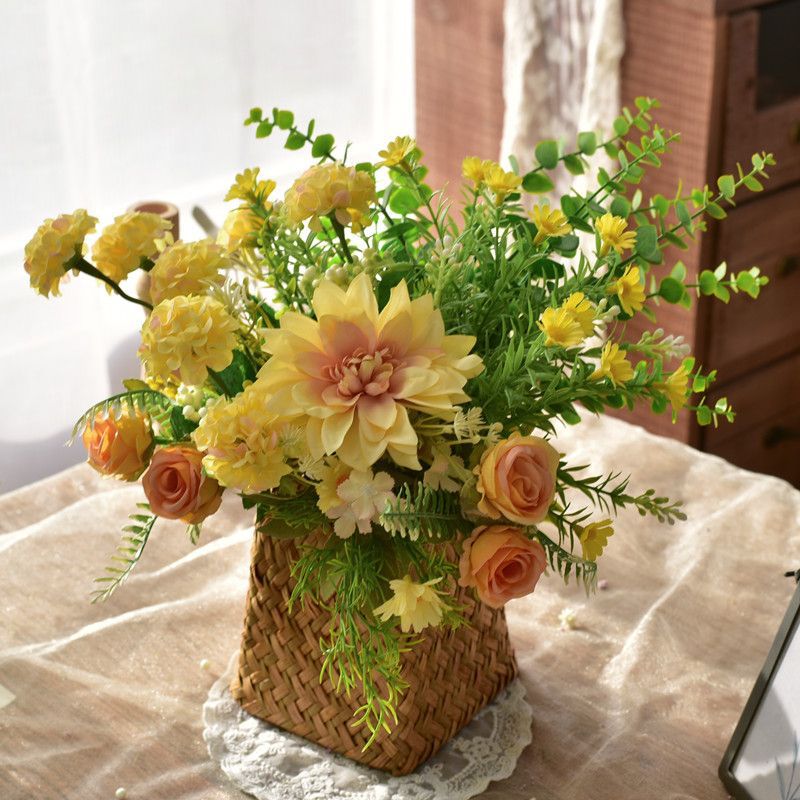 Elegante synthetische Blumenarrangement in geflochtenem Korb