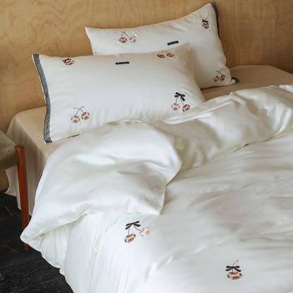 Seidenschimmer Bettbezug Ensemble mit handgestickten Kirschmotiven und Kontrastbesatz