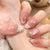 Kunstnagelset mit elegantem französischen Design und zarten Perlenverzierungen Brehn