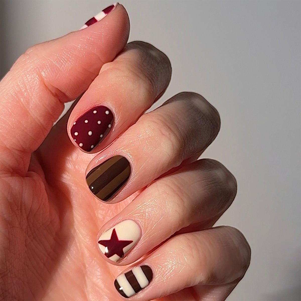 Kunstvolle Nagelkunst mit gestreiftem und punktemuster Brehn