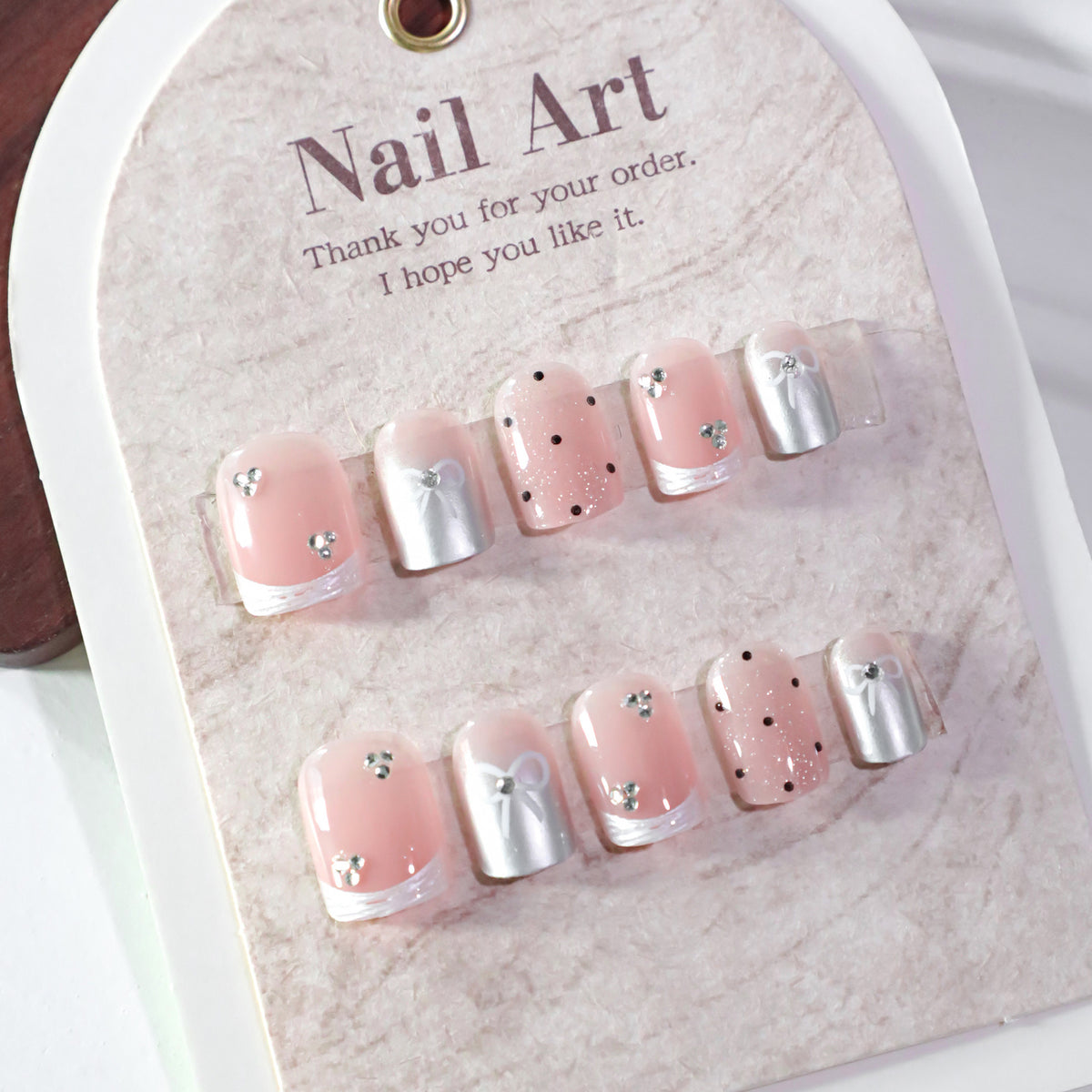 Kunstvolle Nagelkunst mit Schleifen- und Glitzerakzenten Brehn