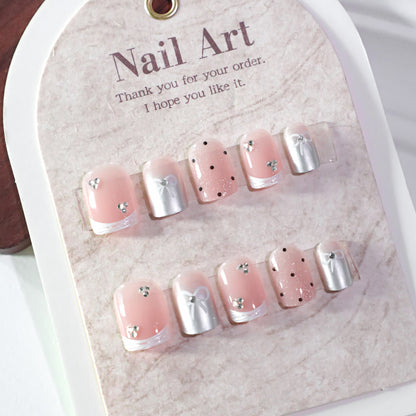 Kunstvolle Nagelkunst mit Schleifen- und Glitzerakzenten Brehn