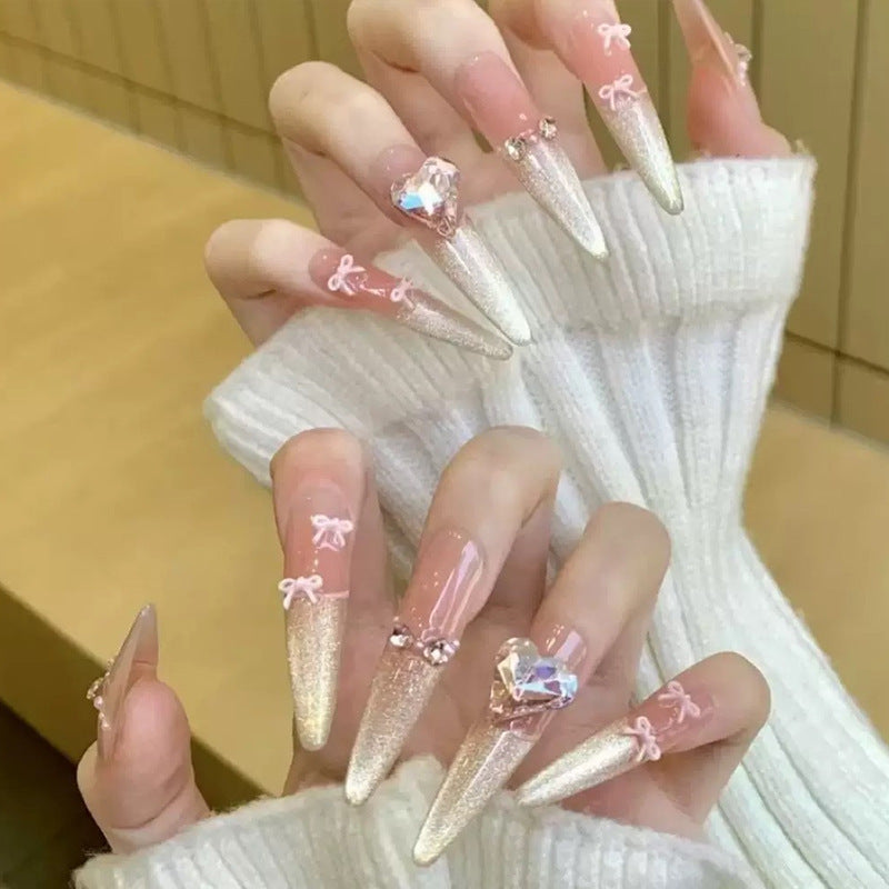 Kunstnagelset mit funkelnden Spitzen und zarten Schleifenverzierungen Brehn