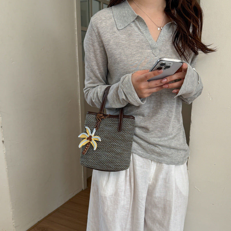 Gewebte Strandhandtasche mit dekorativem Charm