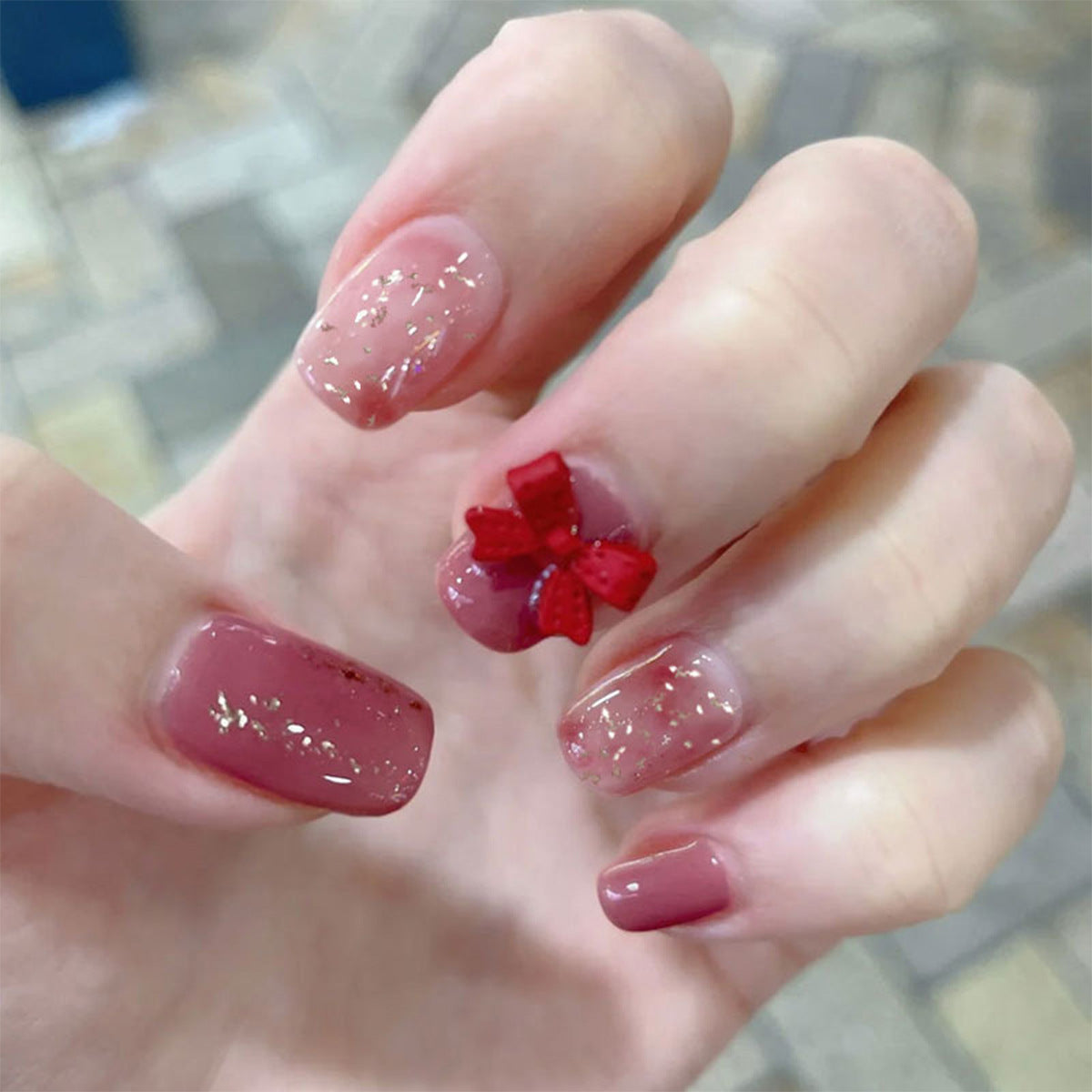 Künstliche Nagelkunst mit Glitzerverzierungen und niedlichem Schleifenmotiv Brehn