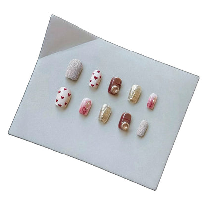 Künstlerisches Press-On-Nagelset mit Herz- und Glitzerelementen