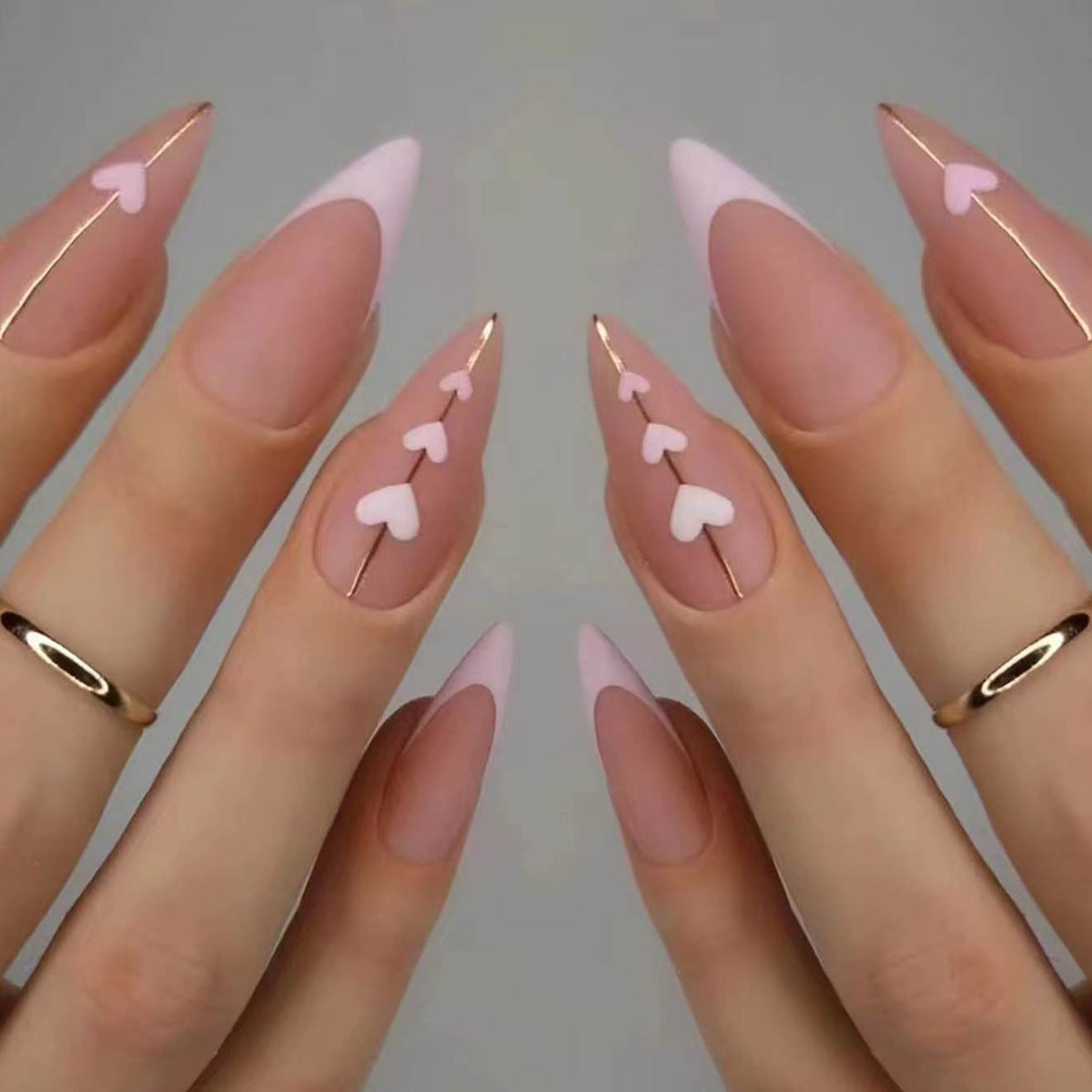 Kunstvolle Stiletto-Nägel mit herzförmigen Akzenten Brehn