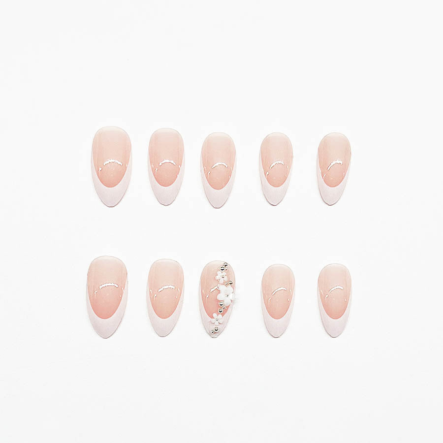 Kunstnagelset mit filigranen Blütenverzierungen und elegantem French Design Brehn