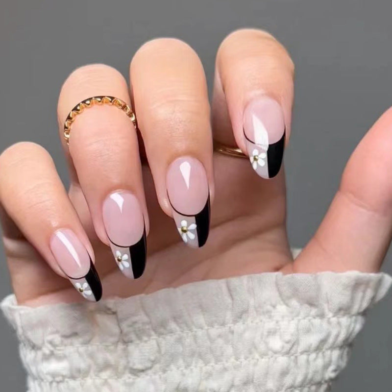 Kunstvolle Nagelkunst mit eleganten Schwarz-Weiß-Design und floralen Akzenten Brehn