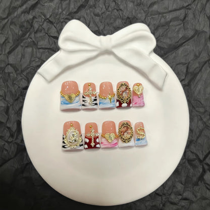 Künstlerisches Press-On-Nagelset mit goldenen Akzenten und einzigartigen Designs
