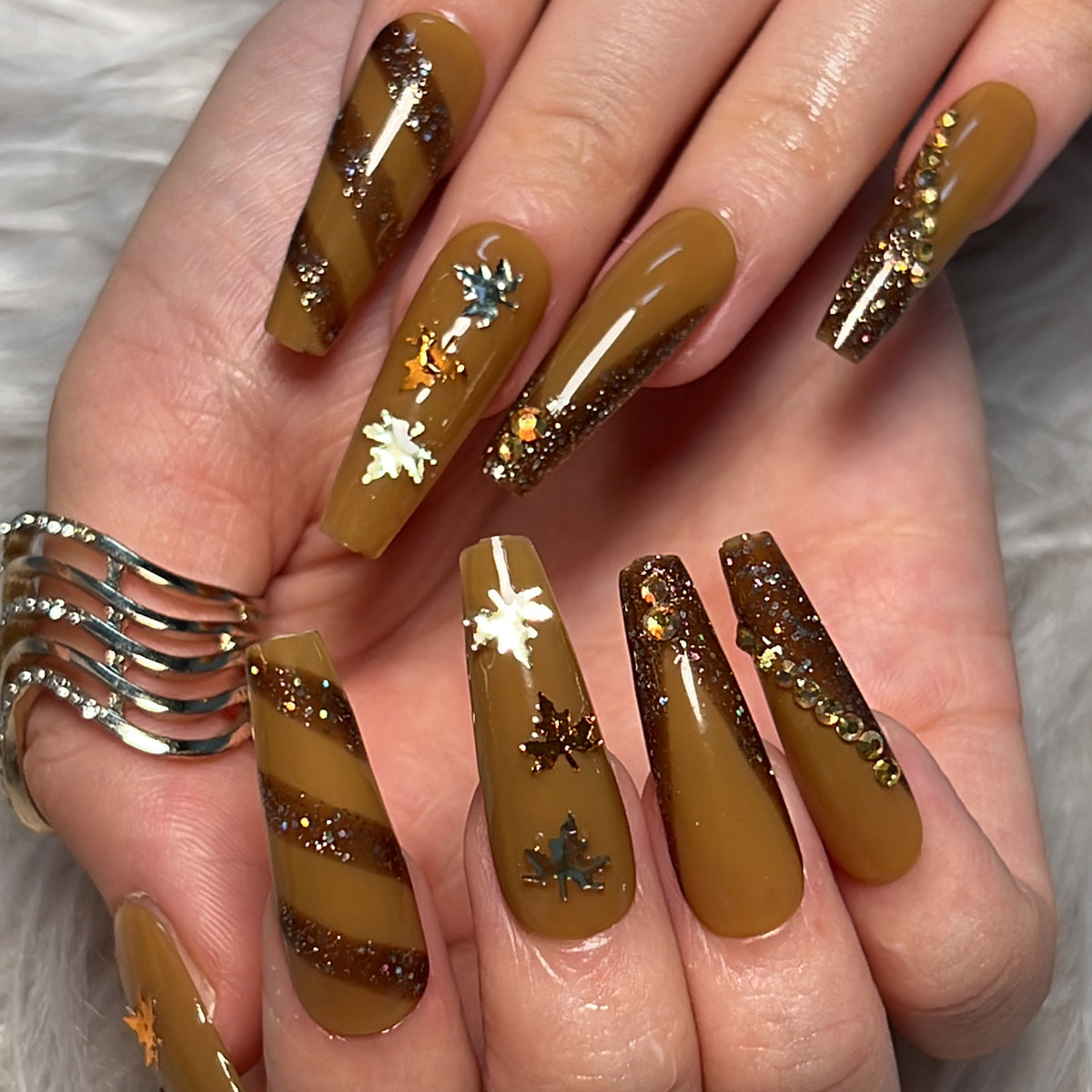 Kunstvolle Nagelkunst mit Glitter- und Blätterdesign Brehn