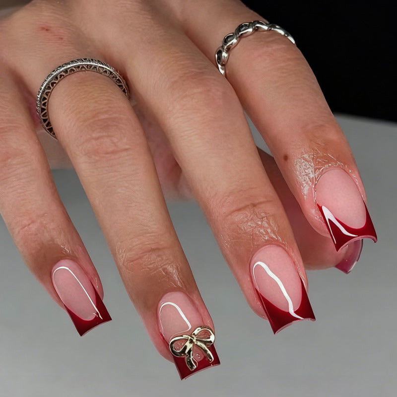Kunstnagelset mit eleganten roten Spitzen und raffinierten Schleifenverzierungen Brehn