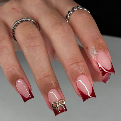 Kunstnagelset mit eleganten roten Spitzen und raffinierten Schleifenverzierungen Brehn