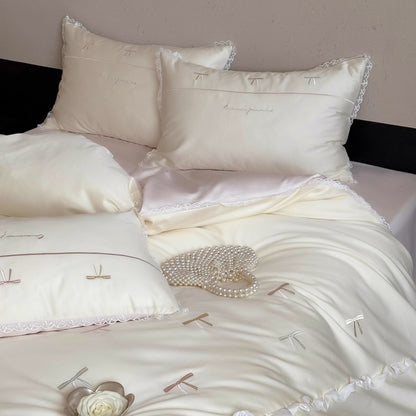 Elegante Bettwäschegarnitur aus seidig-feinem Satin mit bestickten Schleifen und Spitzenbordüre