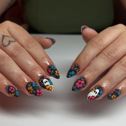 Kunstnagelset mit gruseligem Halloween-Design und bunten Blütenakzenten Brehn