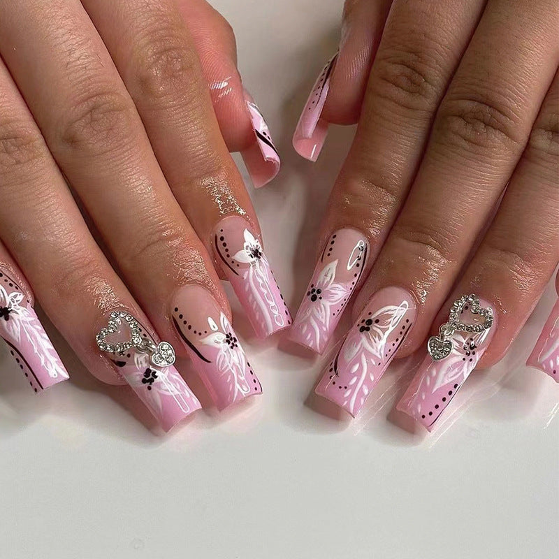 Kunstvolle Nagelkunst mit Blumen- und Herzmotiven Brehn
