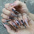 Künstlerische Stiletto-Nagelverlängerungen mit schwarzen Details Brehn
