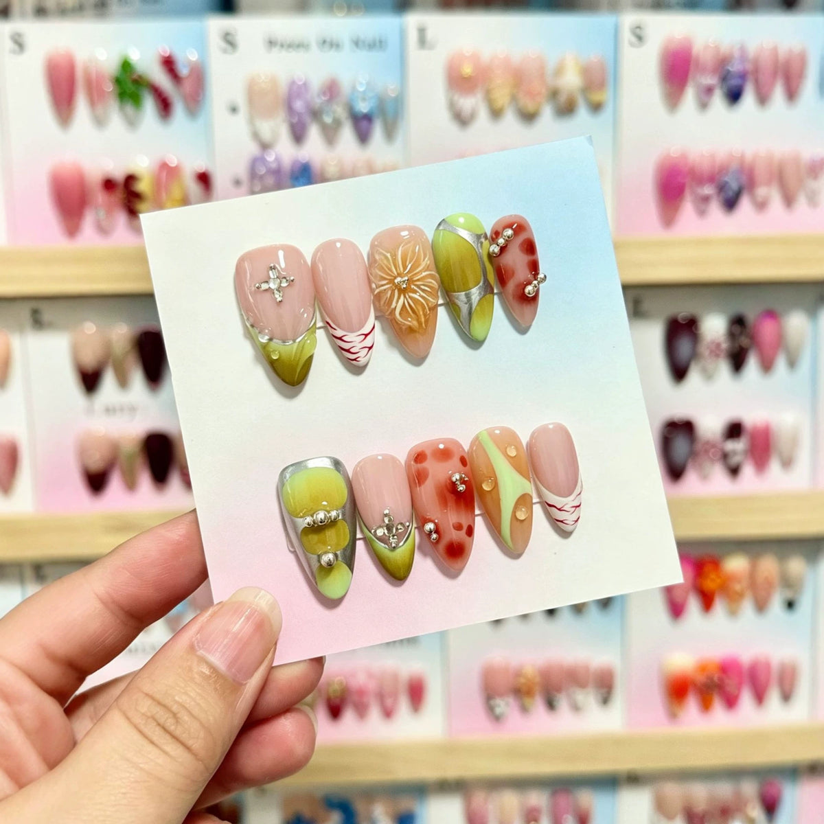 Künstlerisches Press-On-Nagelset mit dekorativen floralen und Juwelenelementen