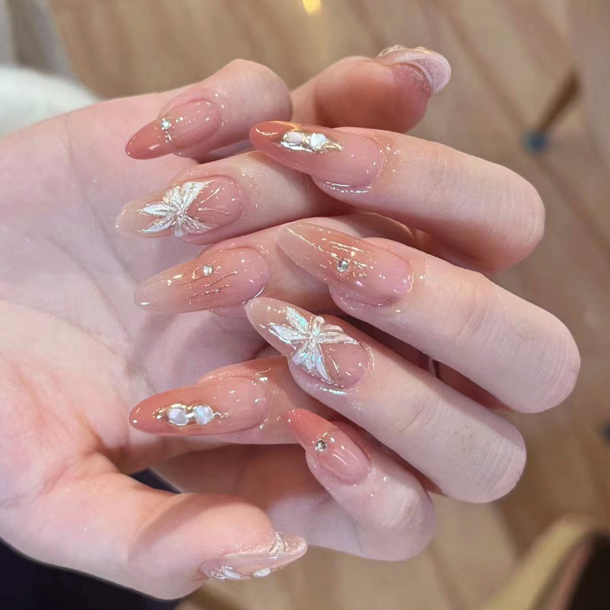 Künstliche Nagelverlängerungen mit floralen Motiven und Glitzerakzenten Brehn