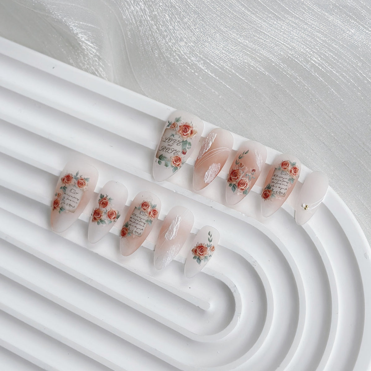 Künstlerisches Press-On-Nagelset mit floralem und Textdesign
