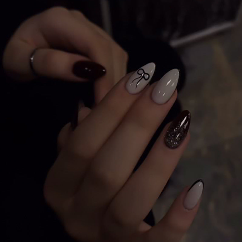 Kunstvolle Nagelkunst mit elegantem Schleifenmuster und Glitzer akzenten Brehn