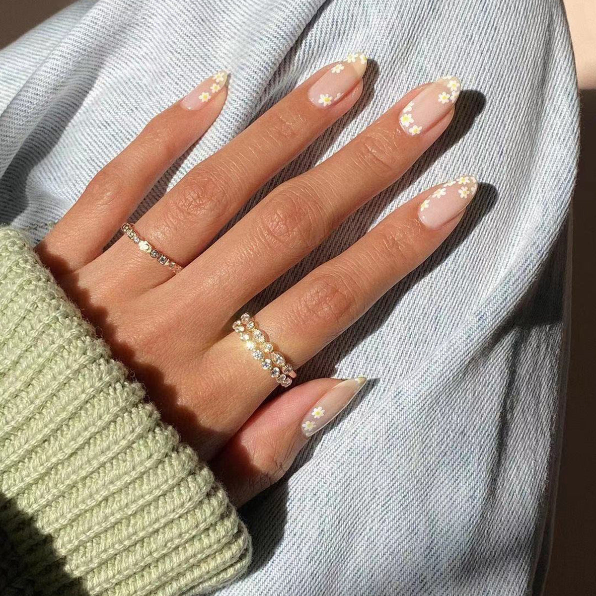 Künstliche Nagelkunst mit floralem Design und Glitzerakzenten Brehn