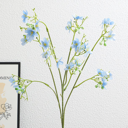 Künstlicher Blütenzweig mit zarten blauen Blumen und grünen Beeren Brehn