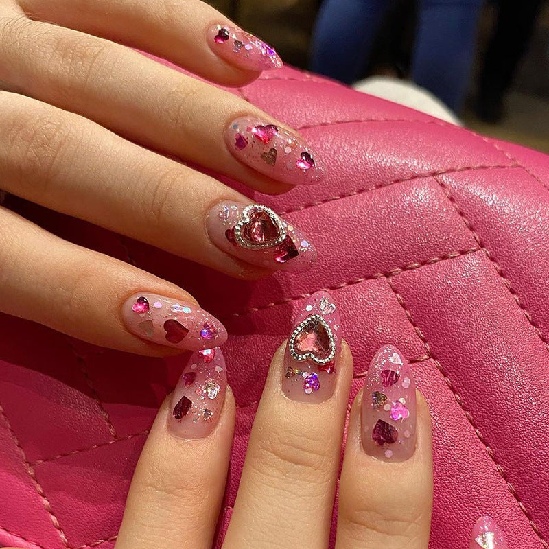 Kunstvolle Nagelkunst mit verspielten Herzmotiven und Glitzer Brehn