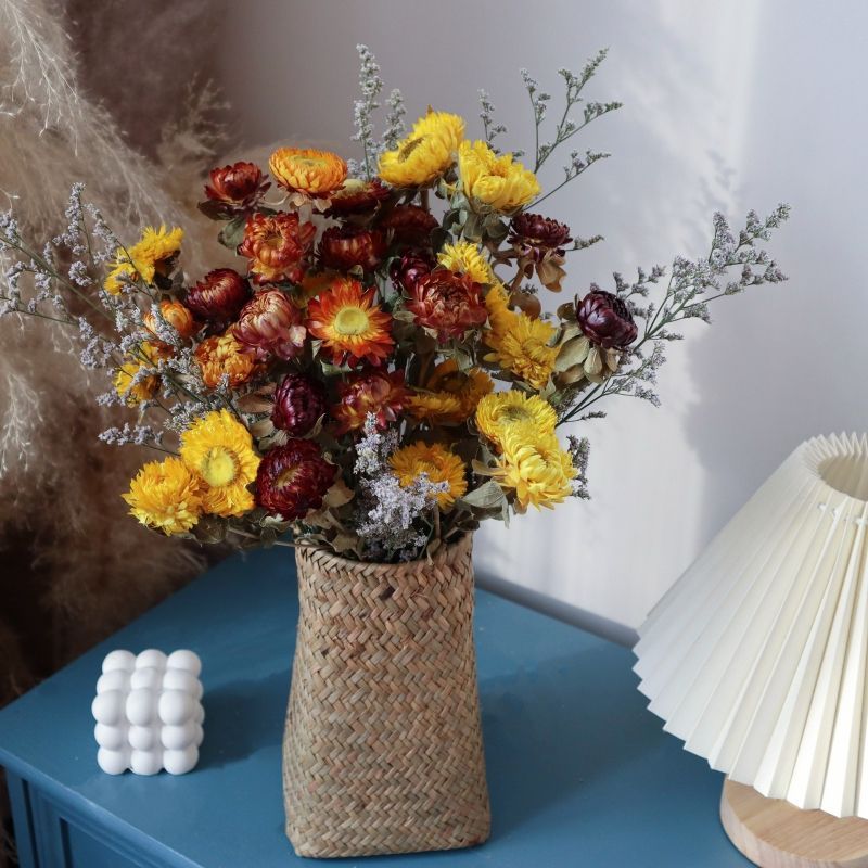 Elegantes künstliches Blumenarrangement im geflochtenen Korb