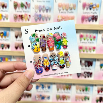 Künstlerisches Press-On Nagelkunstset mit lebhaften Blumen- und Schmetterlingsdesigns