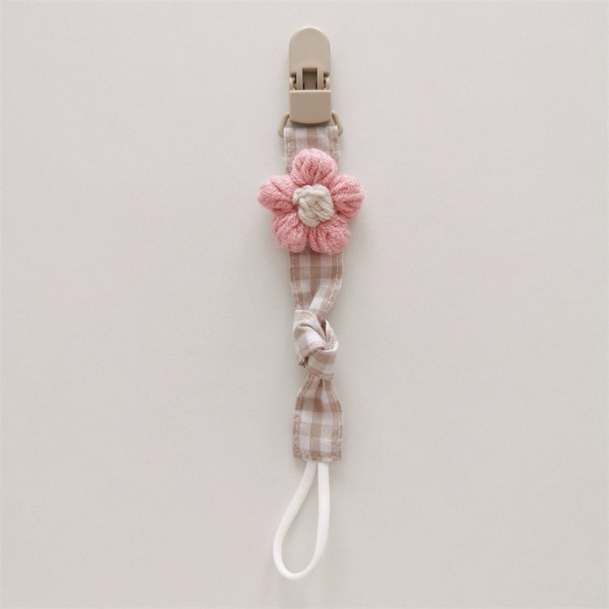 Handgemachter Baumwoll-Schnullerclip mit Gingham-Gurt und gestrickter Blume