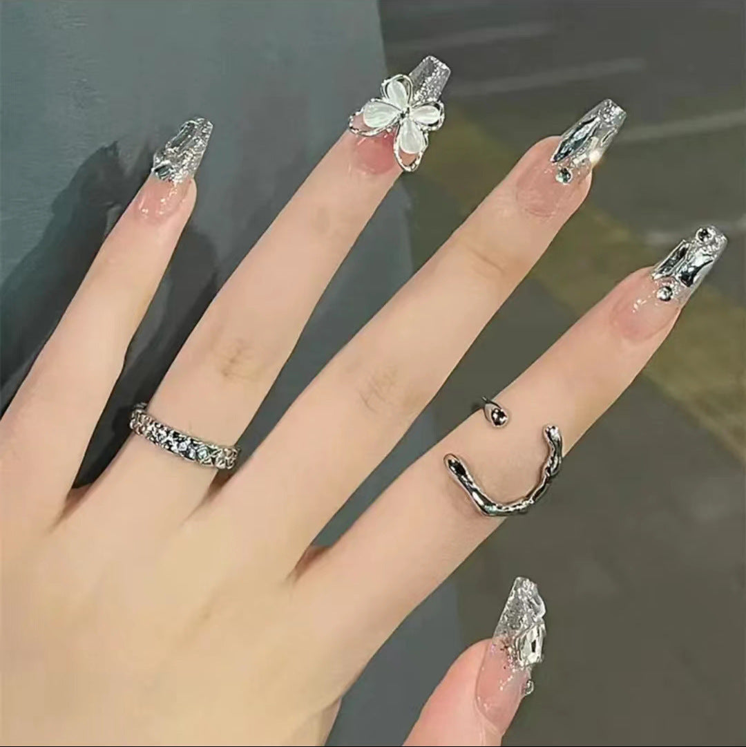 Kunstvolle Nagelkunst mit Glitzer- und Schmetterlingselementen Brehn