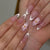Kunstvolle French-Tip Nagelverlängerungen mit Blumenakzenten Brehn