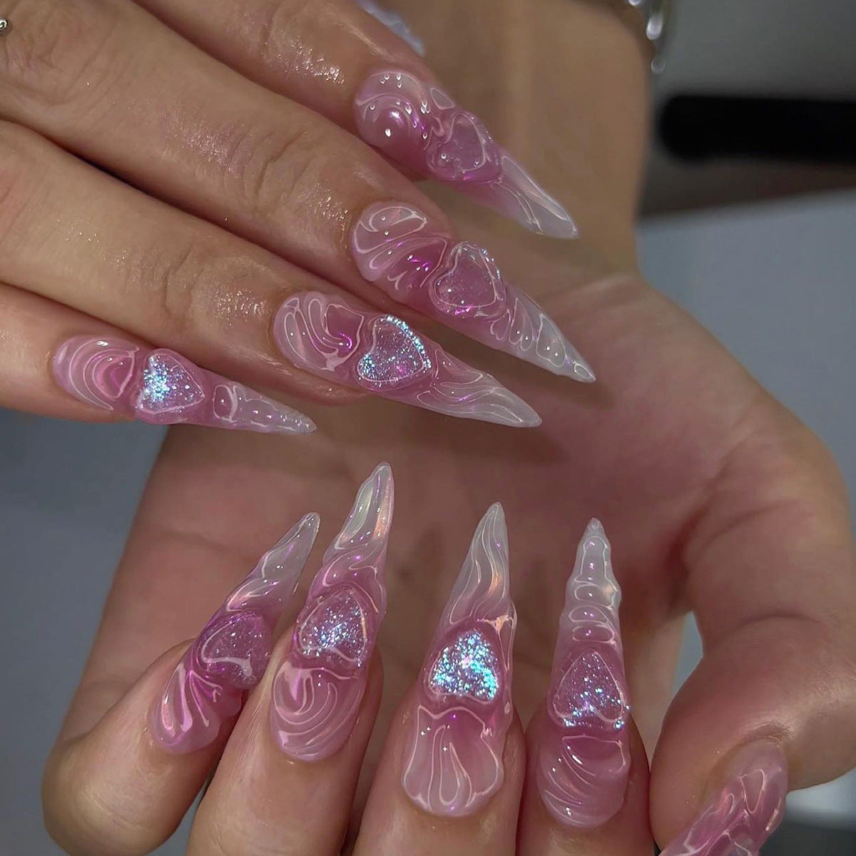 Kunstvolle Stiletto-Nägel mit Herz-Design und Glitzerakzenten Brehn
