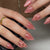 Kunstnagelset mit glamourösem Glitzer-Design und floralem Akzent Brehn