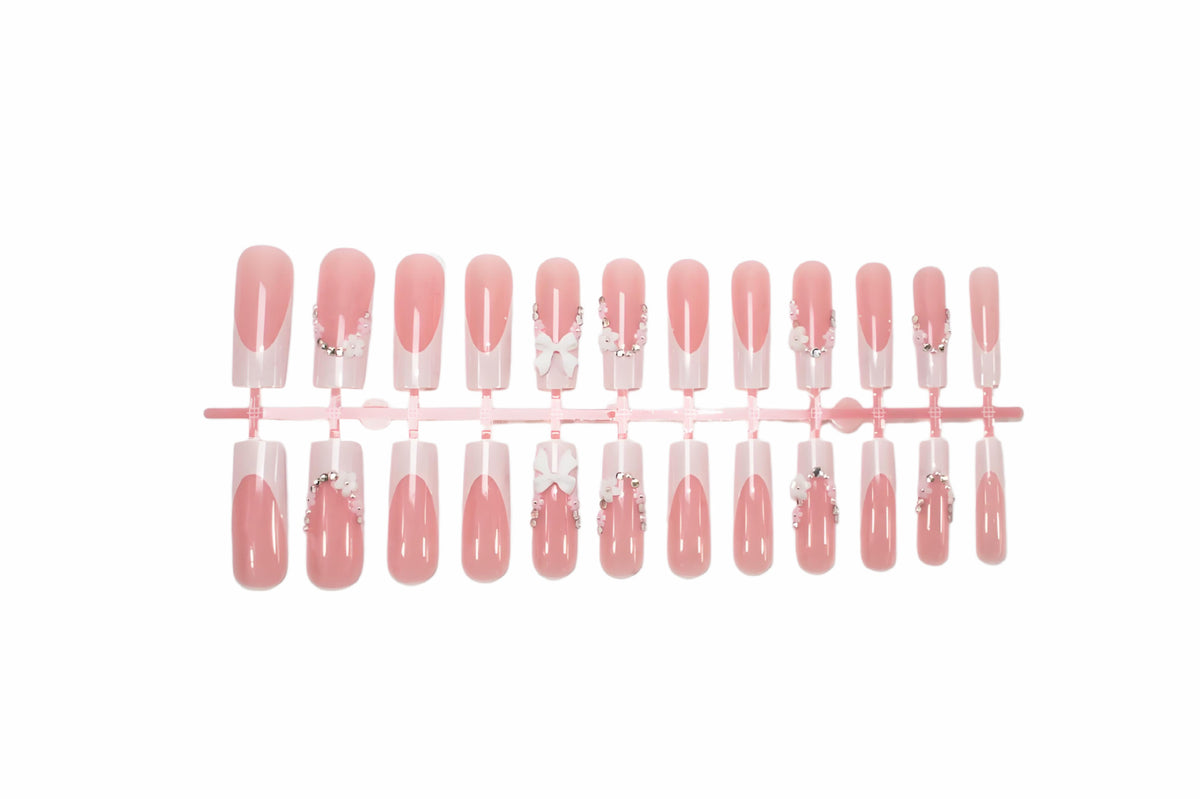 Kunstnagelset mit eleganten Schleifen und Glitzerakzenten Brehn