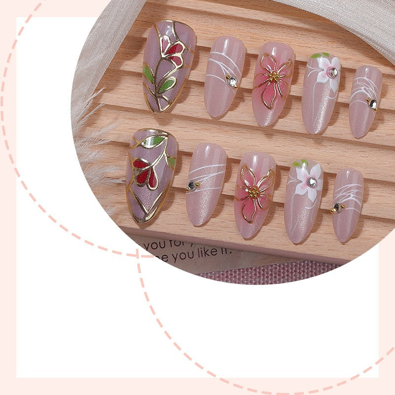 Kunstnagelset mit filigranen floralen Verzierungen und glänzenden Details Brehn