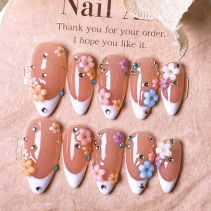 Kunstnagelset mit zarten Blumenverzierungen und funkelnden Strasssteinen Brehn