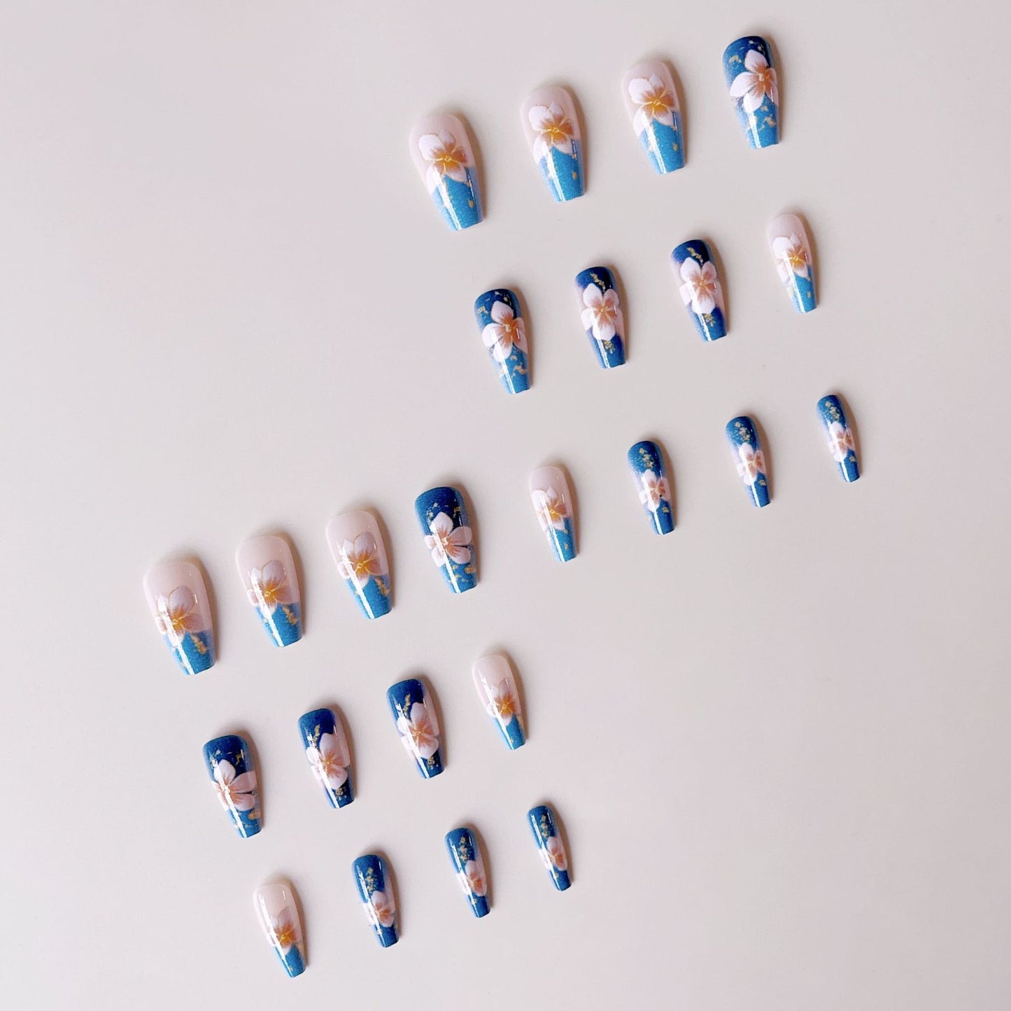 Kunstnagelspitzen mit floralen Akzenten und Glitzer Brehn