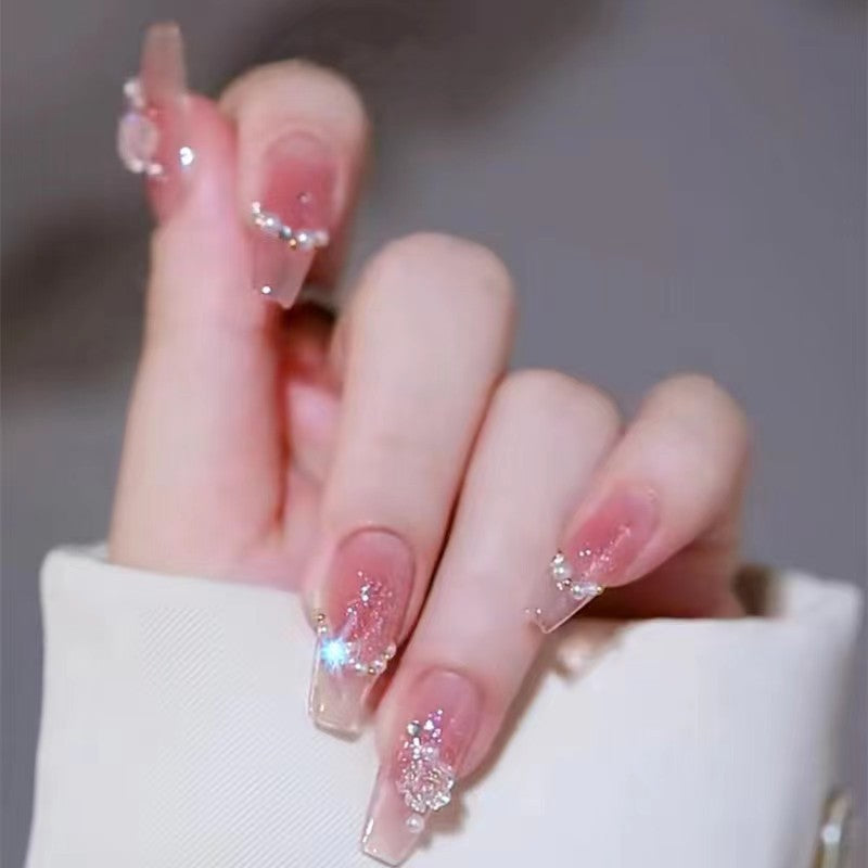 Kunstvolle Nagelkunst mit Schmetterlings- und Perlendetails Brehn