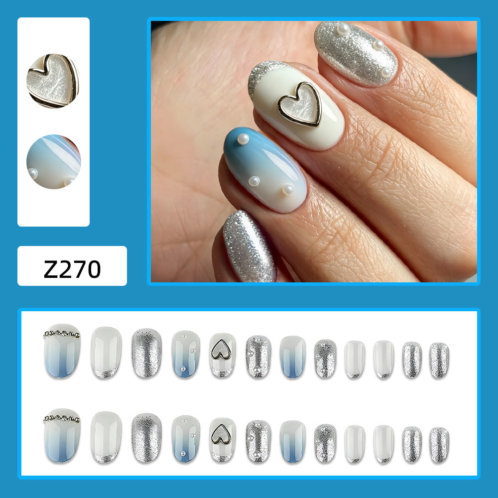 Glamouröse Kunstnägel mit Herz-Design und Perlendetails Brehn