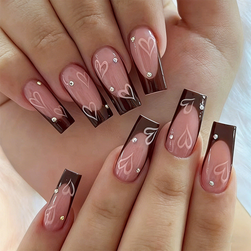 Elegante Kunstnägel mit Herz-Muster und Glitzerakzenten Brehn