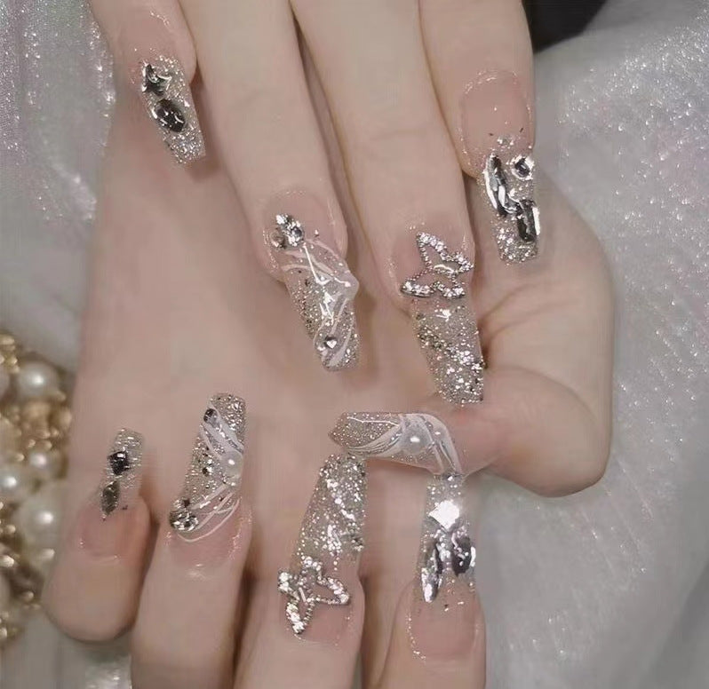 Kunstvolle Nagelkunst mit Glitzer- und Blumenapplikationen Brehn