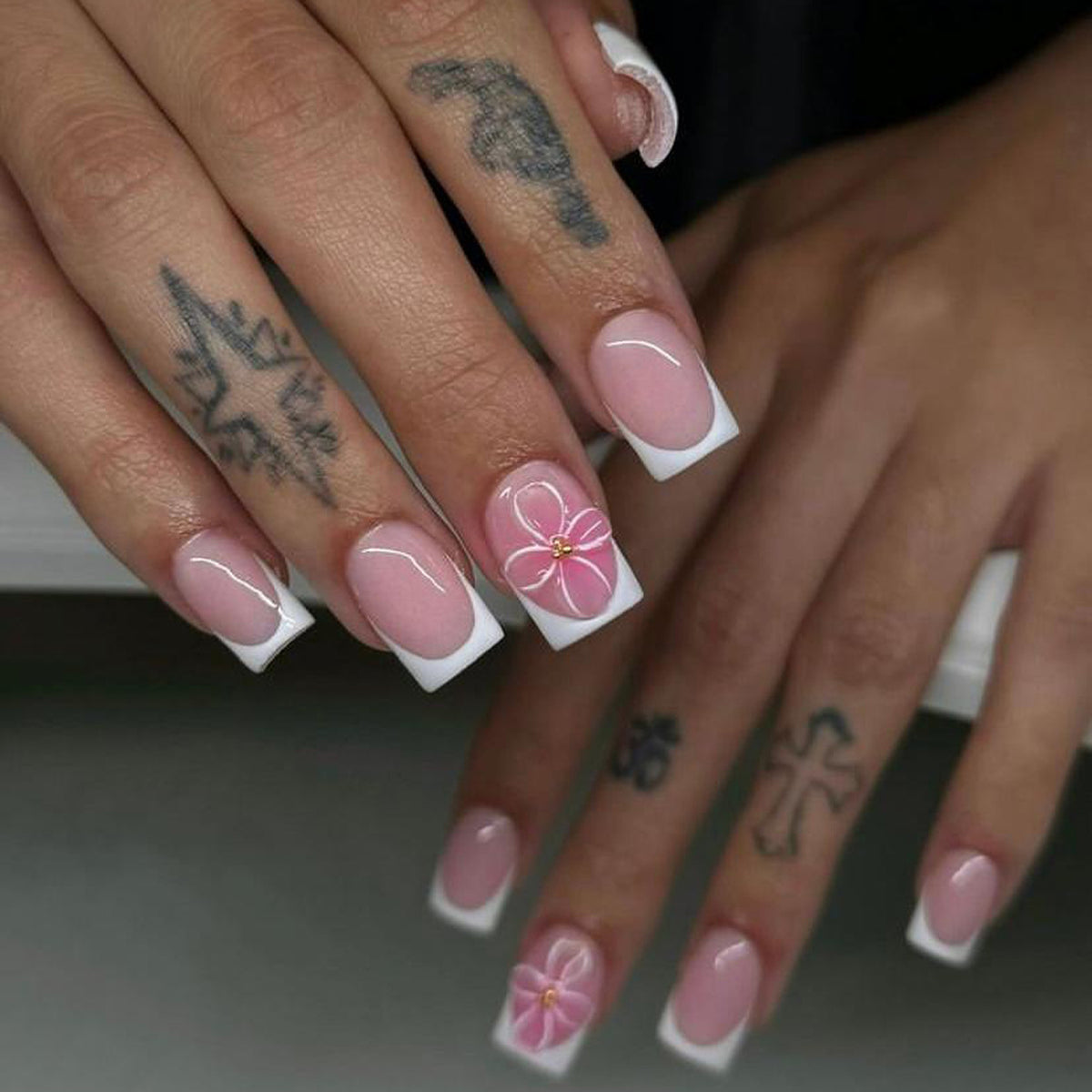 Kunstvolle Nagelkunst mit zarten Blüten und eleganter French-Spitze Brehn
