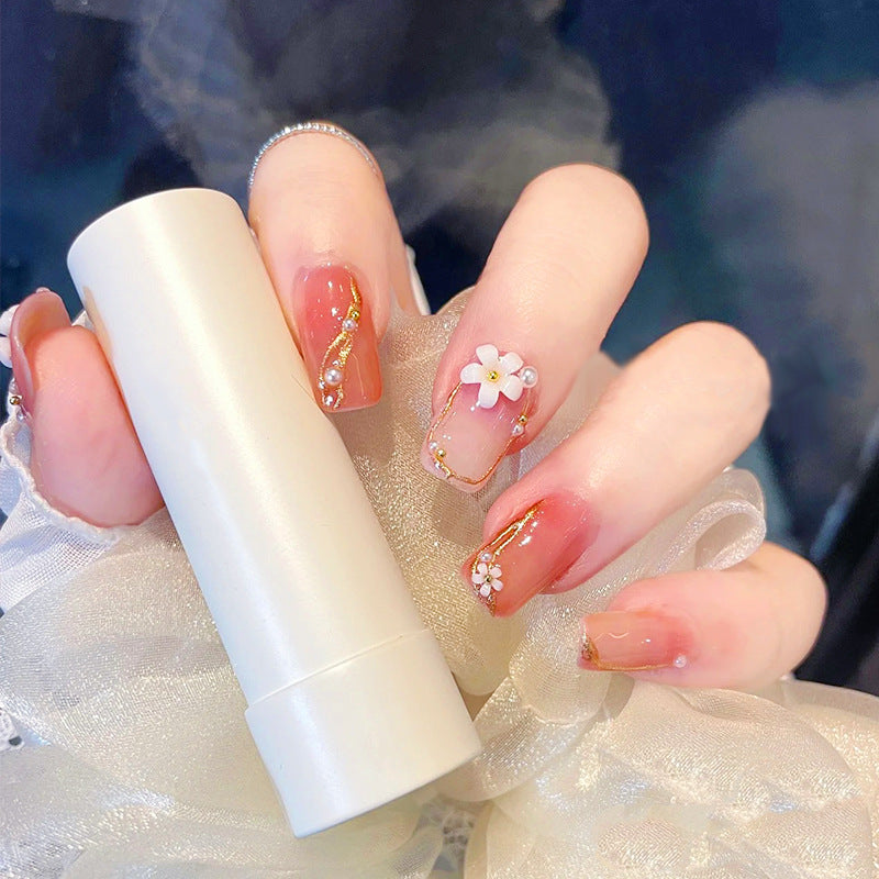 Kunstnagelset mit eleganten Blumendekoren und glamourösen Perlenakzenten Brehn
