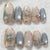 Kunstnagelset mit eleganten Blütenverzierungen und Glanz Brehn