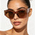 Damen kreative Cat-Eye Sonnenbrille mit transparentem Rahmen und braunen Gläsern Brehn