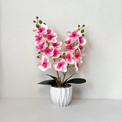 Dekoratives künstliches Orchideenarrangement für die Innendekoration zu Hause